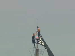 Couple reach top of Empire State Building with banner, before apparent proposal