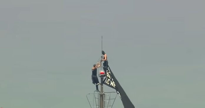 Couple reach top of Empire State Building with banner, before apparent proposal